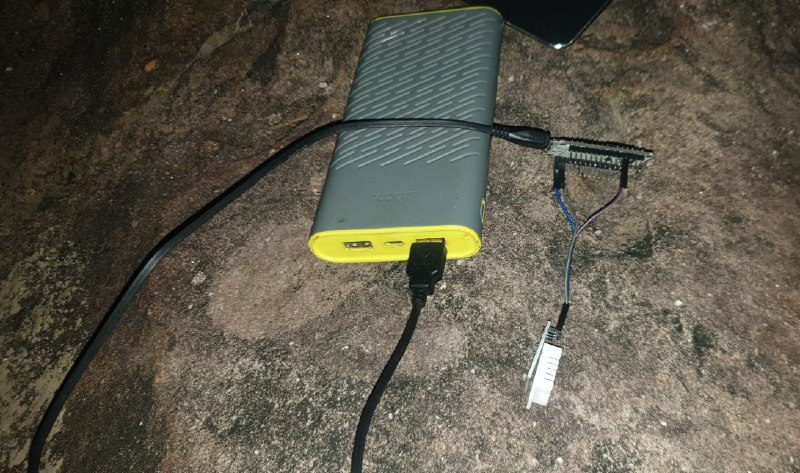 A small sensor wired to a power bank on a rock at night